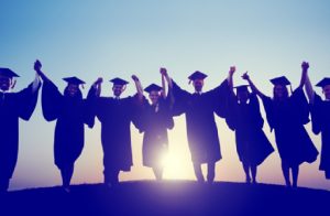 A Group Of Graduates Raising Hands In The Resemblence Of Their Graduation Success.