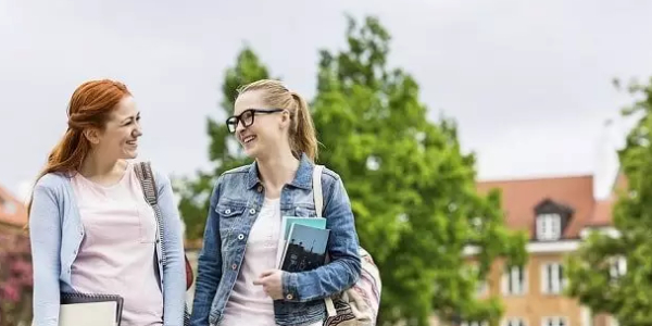 Two College Girls Talking And Smiling About Something.