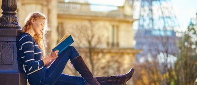 A Young Smiling College Girl Sit In A Place And Studying.