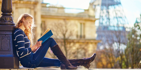 A Young Smiling College Girl Sit In A Place And Studying.