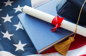 Close Up Of Bachelor Hat And Diploma On American Flag