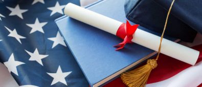 Close Up Of Bachelor Hat And Diploma On American Flag