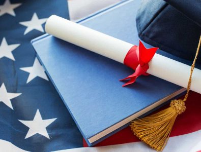 Close Up Of Bachelor Hat And Diploma On American Flag