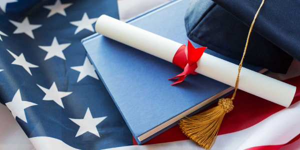 Close Up Of Bachelor Hat And Diploma On American Flag