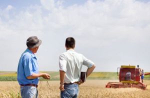 Two Persons Standing On The Ground & Discussing About Farming.