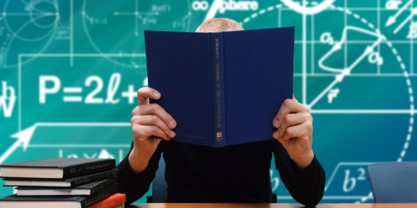 A Person Studying With A Book Hiding His Face.