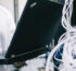 A field engineer is standing at the electrical wiring room with a laptop on his hand.