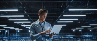 Portrait of a young male IT Specialist using Laptop in a Data Center.